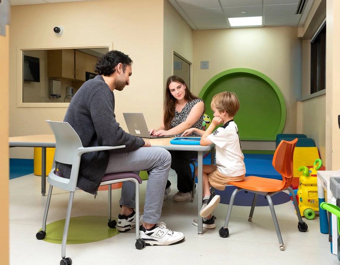 Two adults working in a behavioral health lab with a child.