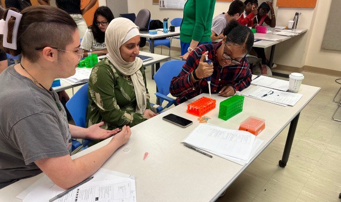Three students working on a lab experiment.