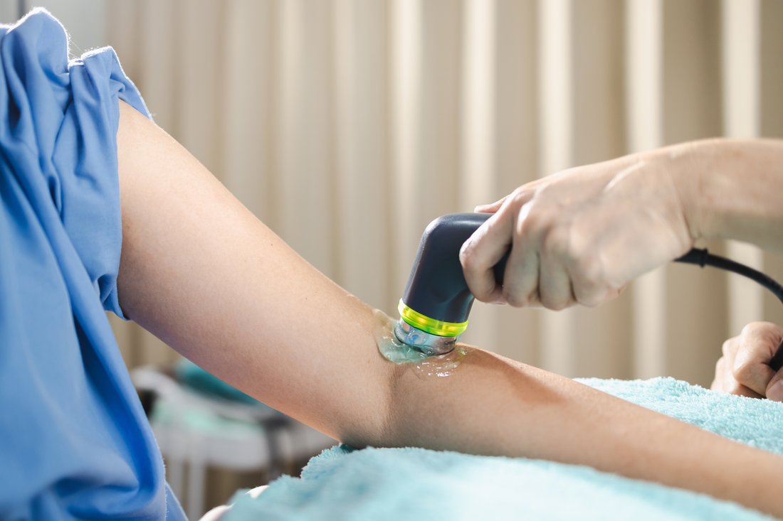 Arm receiving ultrasound therapy.