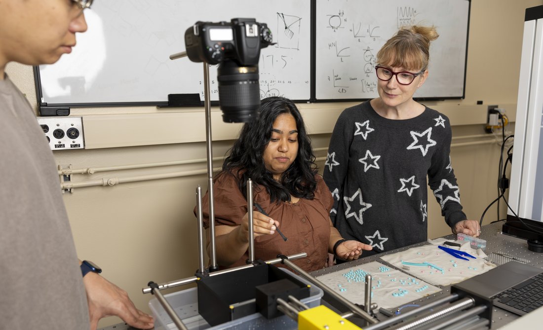 Three people working in a lab.