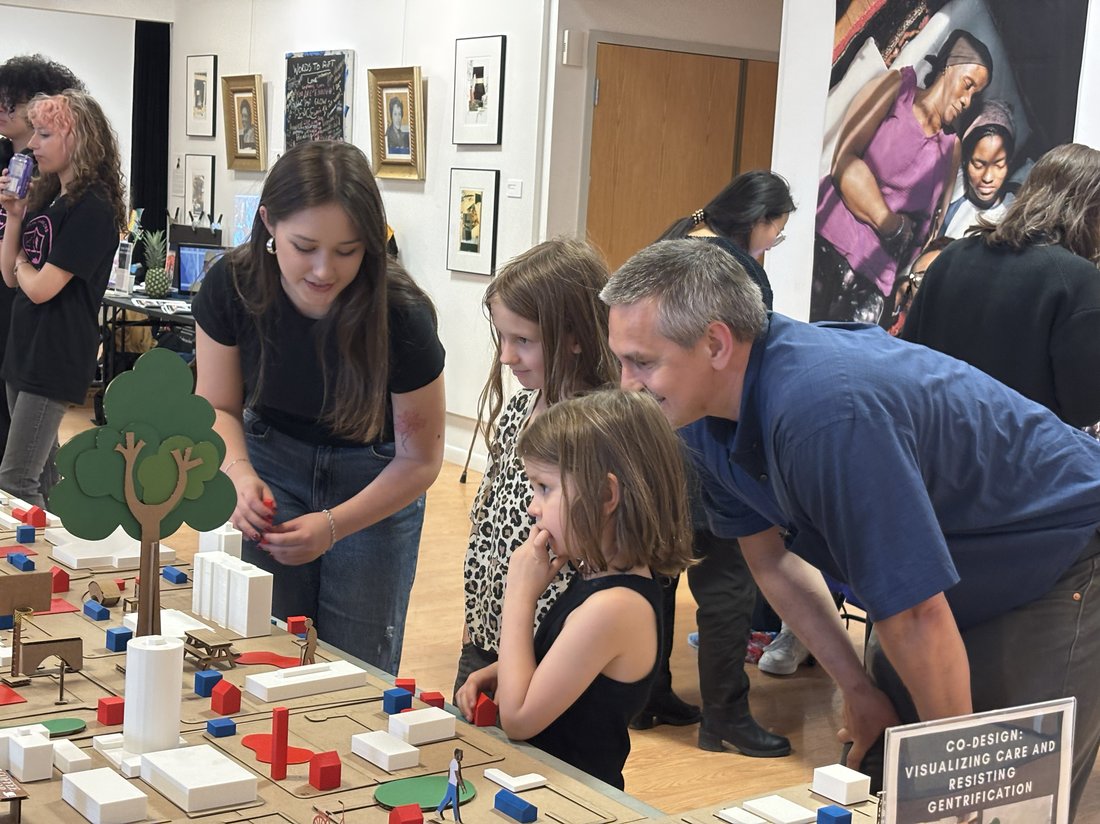 People chatting and looking over an exhibit.