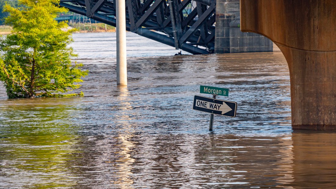 Flooded road with street signs just above the water line.