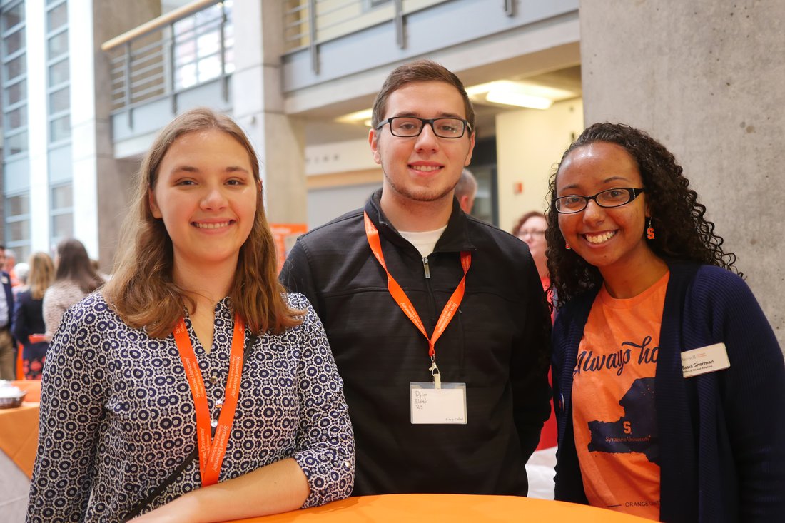 three alumni with orange lanyards