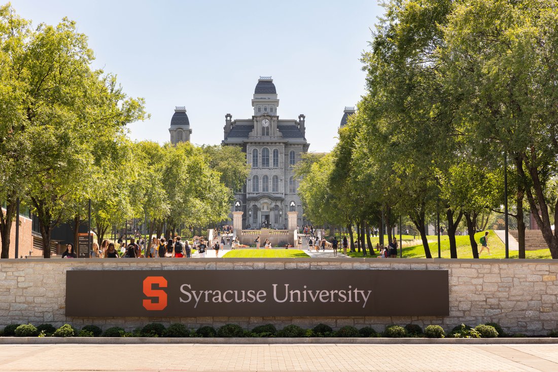 Syracuse University sign with Hall of Languages in the background.