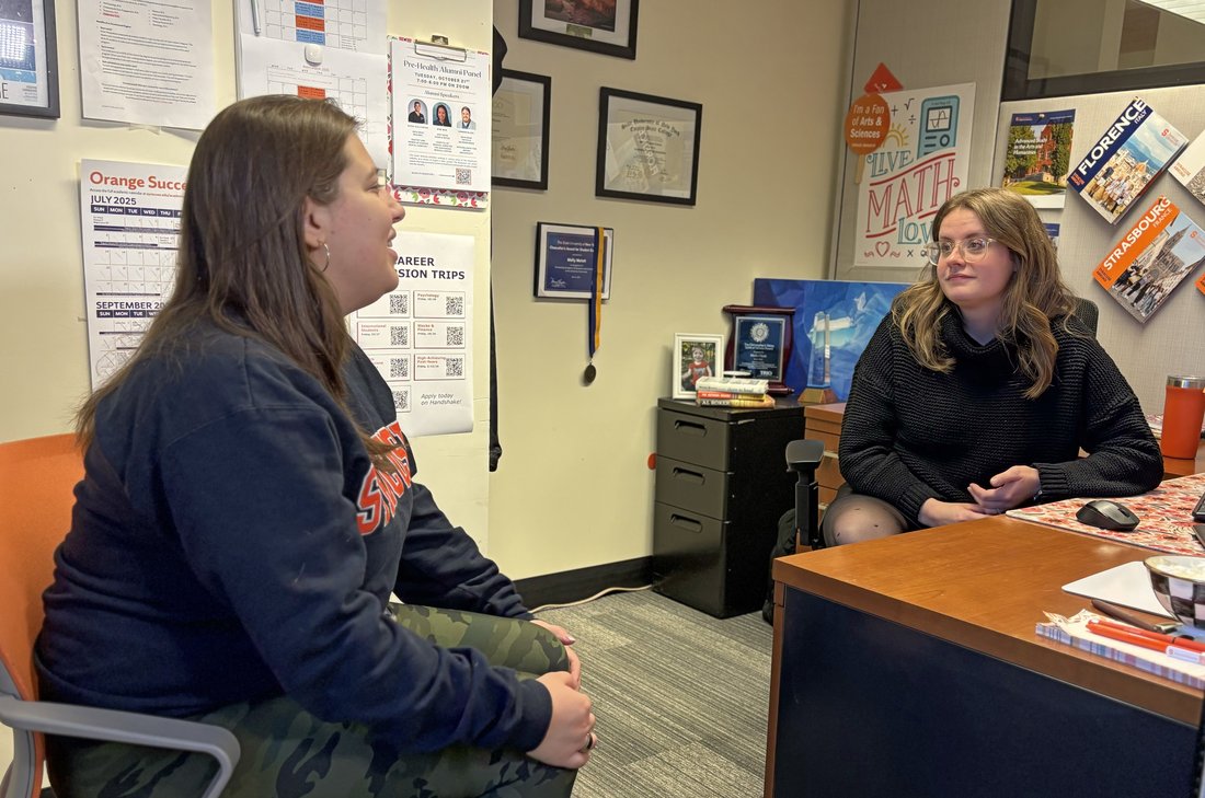 Two people having a conversation in an office.