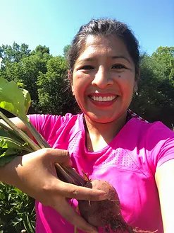 Mariaelena Huambachano holding vegetables she's grown