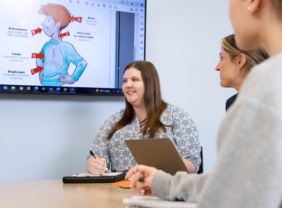 People seated at a table during a conference.