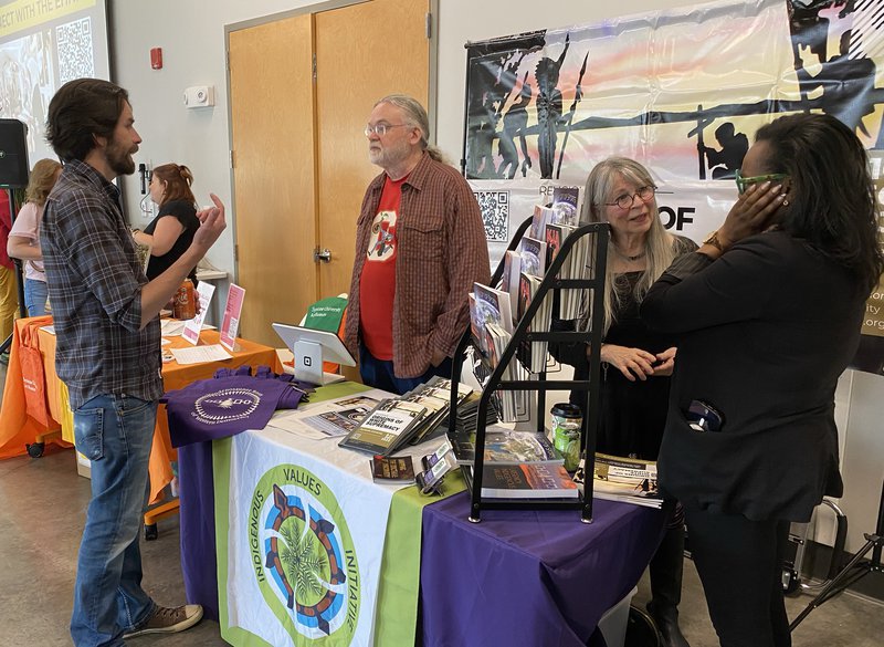 Religion Prof. Phil Arnold and Sandy Bigtree welcome guests to their Indigenous Values Initiative Table at EHN Showcase Event