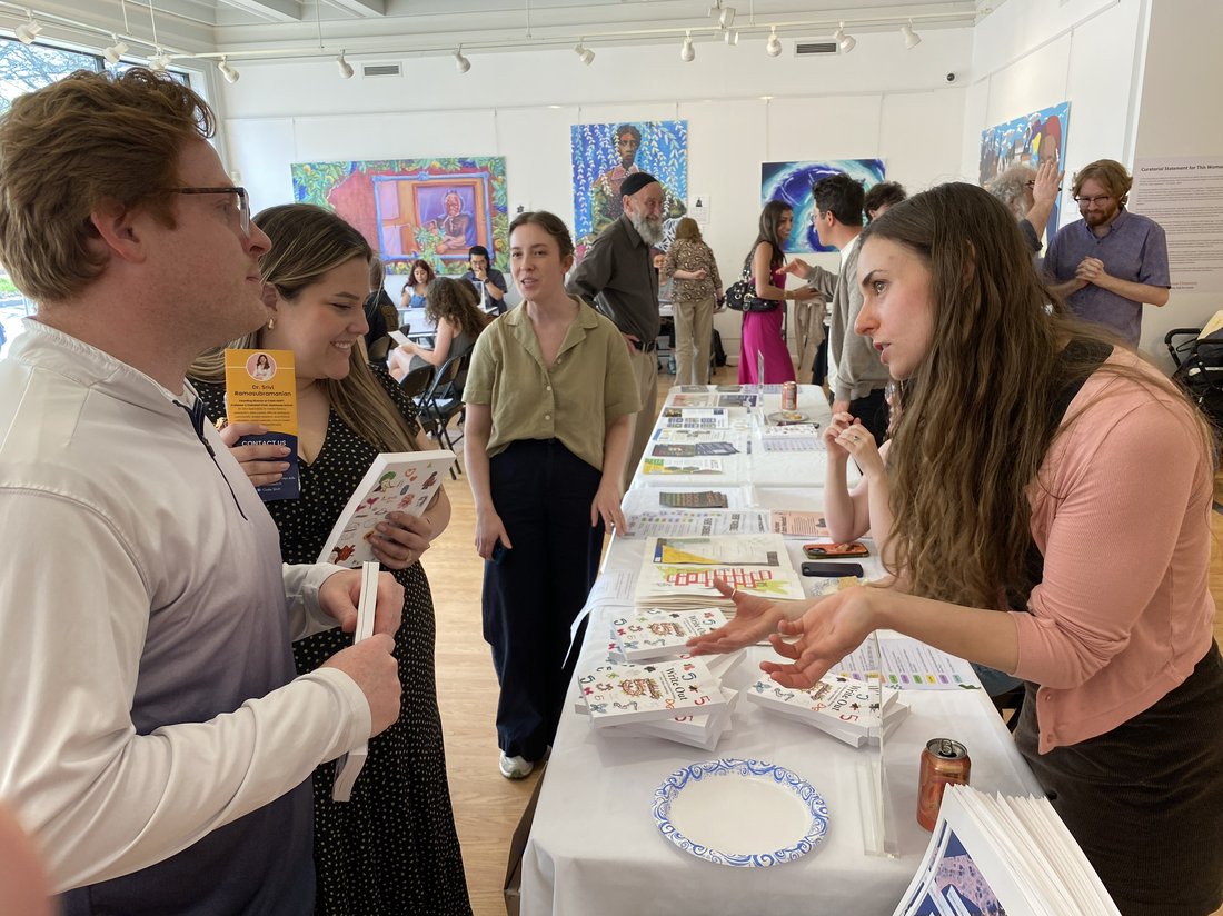 Lauren Cooper G’24 (right), an Engaged Humanities Postdoctoral Fellow in A&S, talks with attendees at the Engaged Humanities Network Community Showcase.