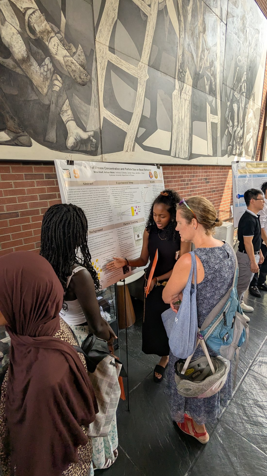Group of people standing in front of a science poster.