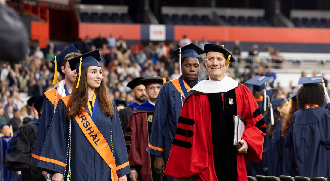 People at a Convocation in cap and gowns.