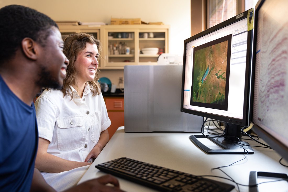Two people viewing a computer.