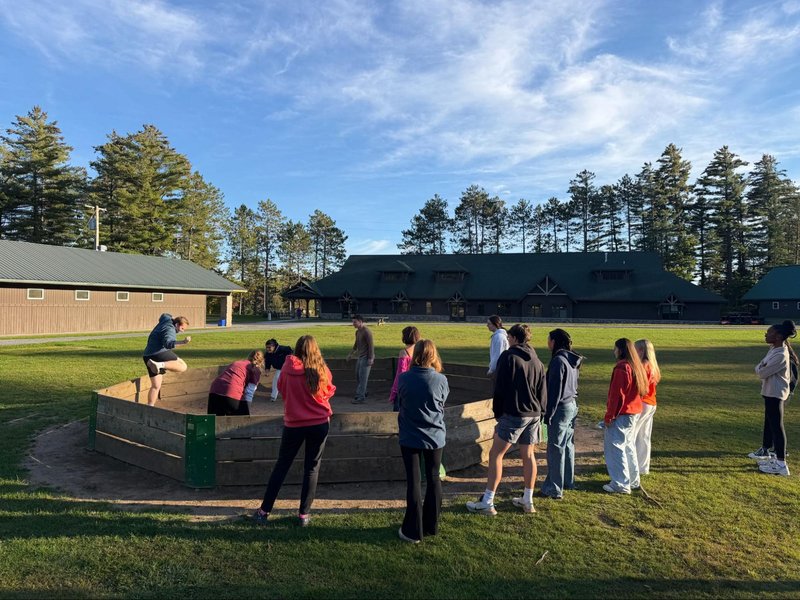 Group of people playing gaga ball at a campground.