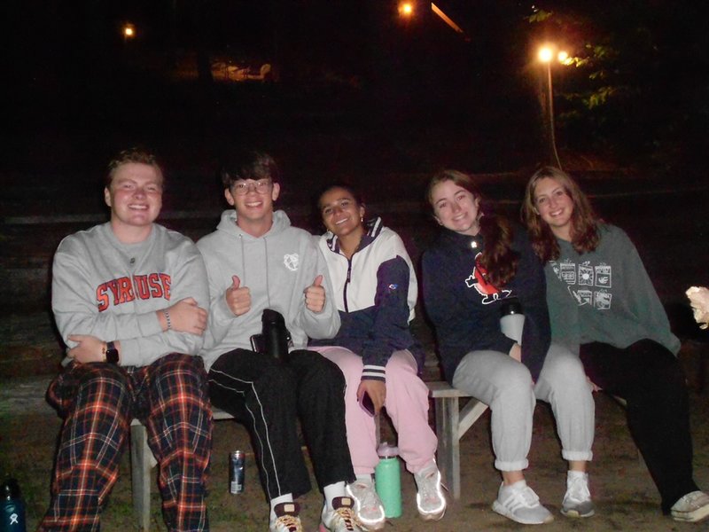 Group of students seated on a bench.