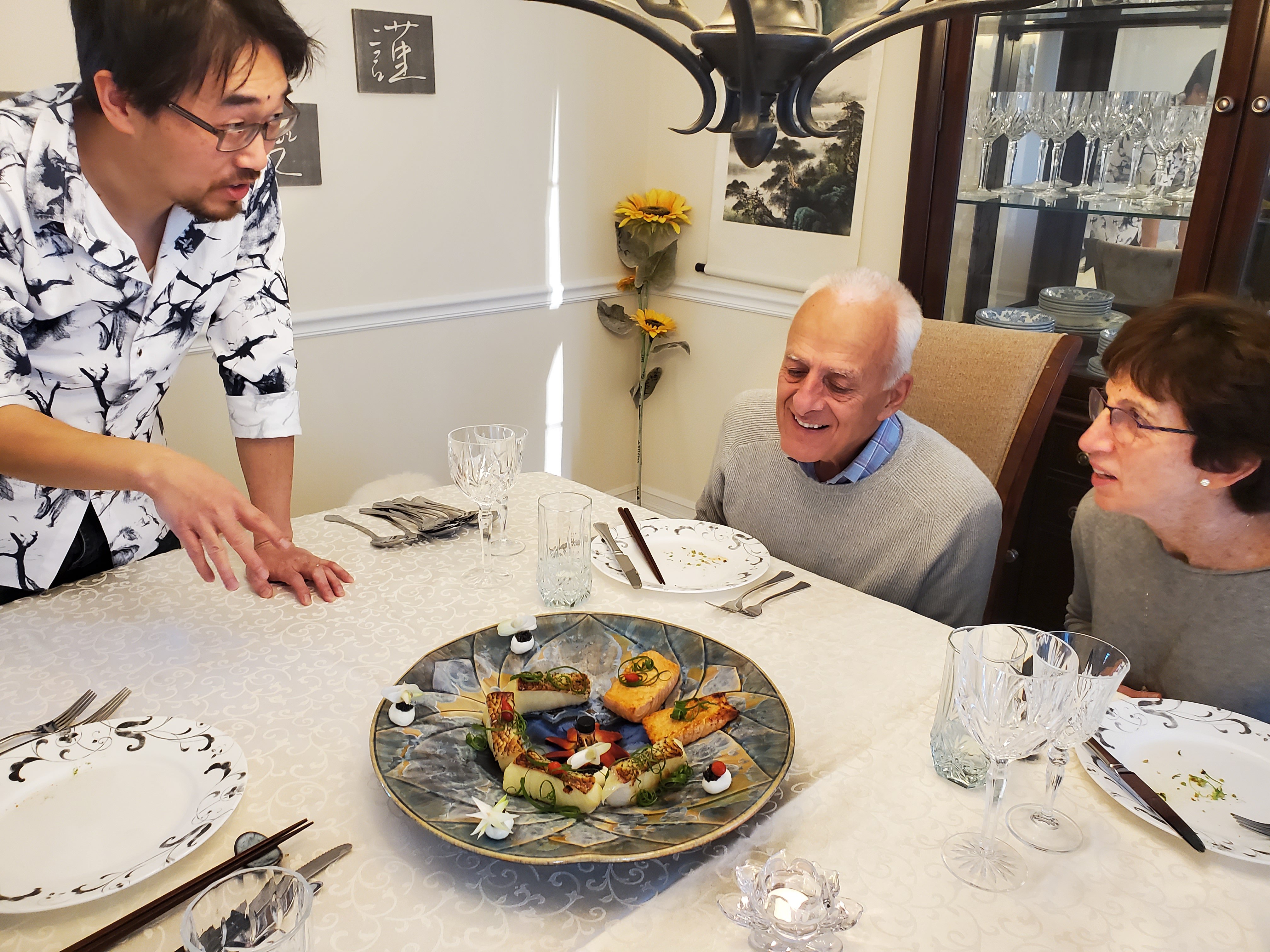 Lu presenting the seafood dish to Mike and Susan Thonis