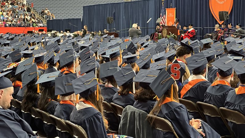 Graduates watching speaker at convocation.