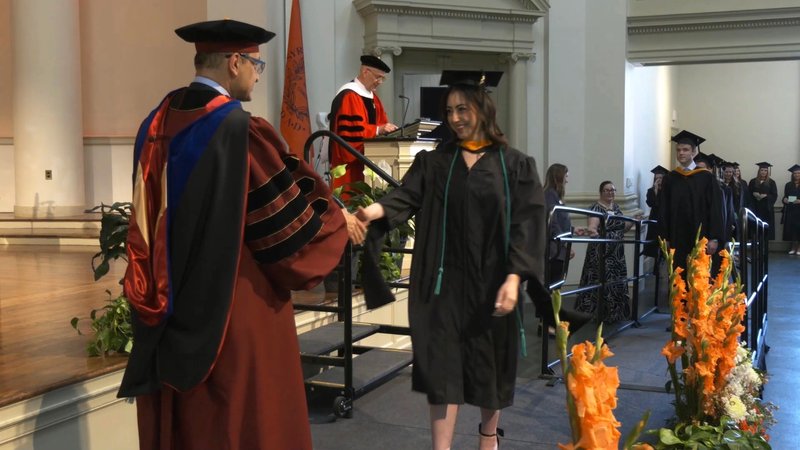 Dean Mortazavi greets graduating master’s students at A&S’ graduate Convocation ceremony.