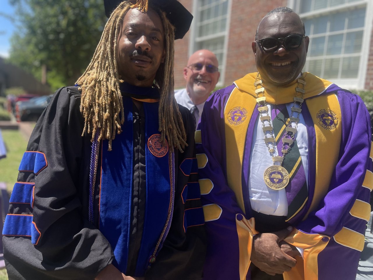 Two people standing together in cap and gowns.