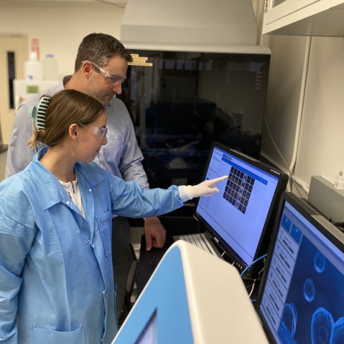 Amber Vandepoele and Mike Marciano looking at a computer screen with data on it.