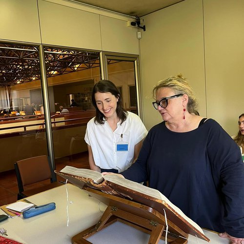 Two people looking over an ancient text.