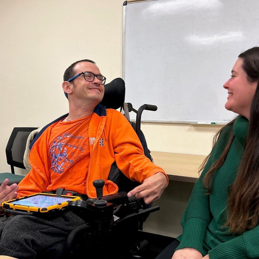 A man in a wheelchair seated beside a woman