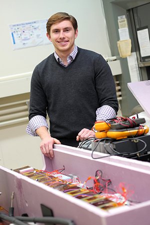 Lentz shown with the CO2 cooling system he built in the Syracuse physics department