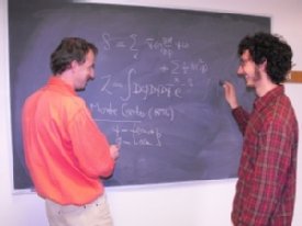 Physics Professor Simon Catterall (left) works on an equation with 2012 Goldwater Scholar Ryan Badman (right)