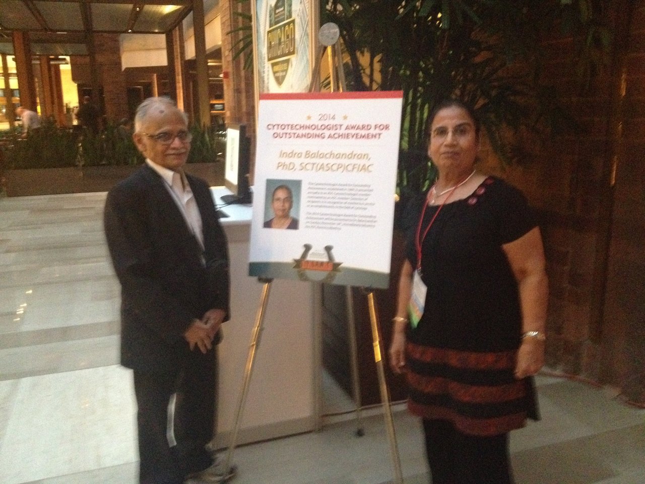 Two people in front of a poster