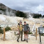 Two people in front of a geothermal feature.