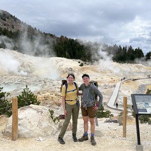 Two people in front of a geothermal feature.