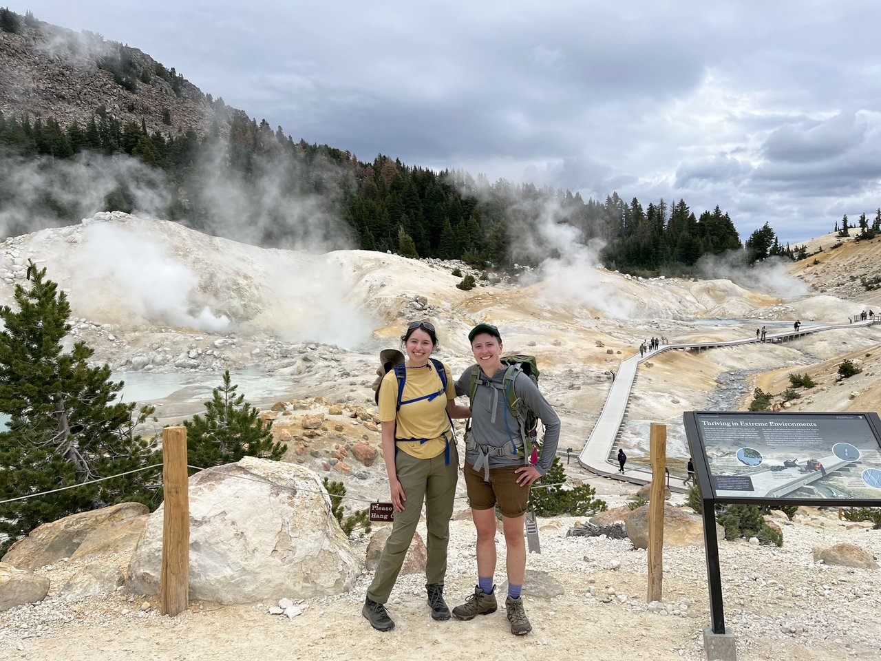 Two people in front of a geothermal feature.