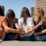 Group of women locking arms.