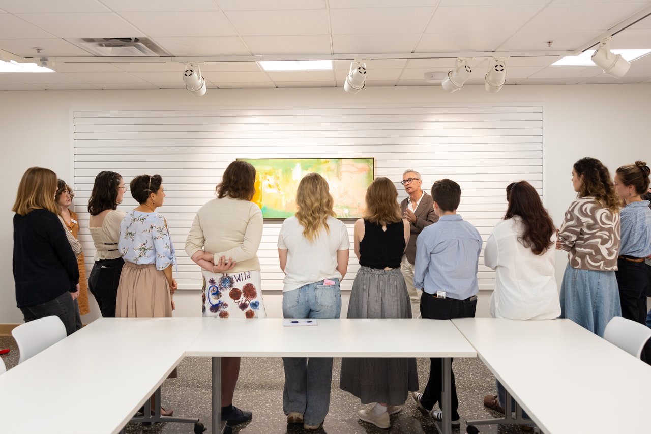 Group of students watching someone discuss an art work.