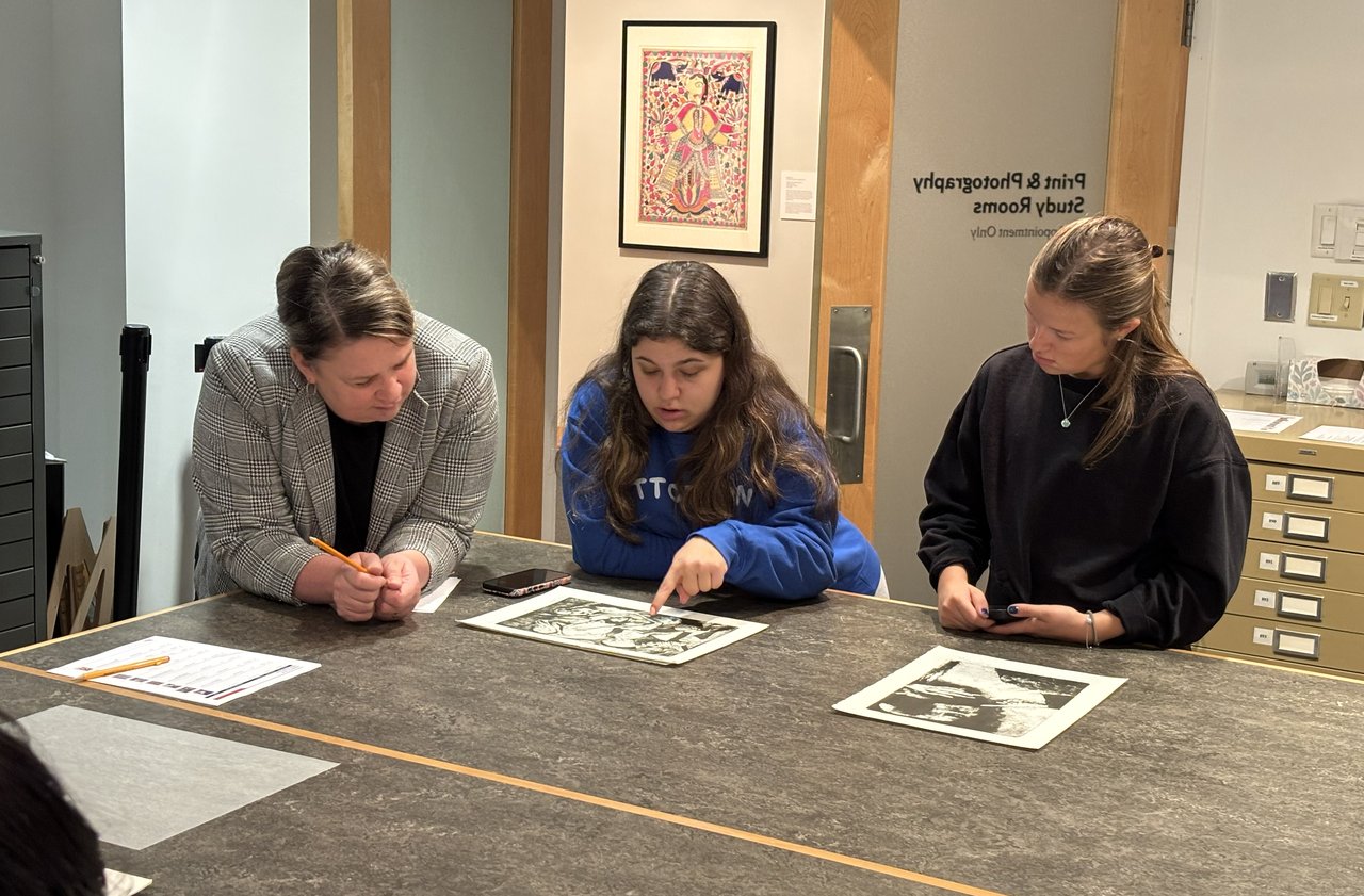 Three people viewing an artwork.