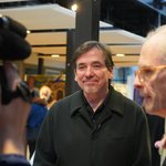 Person being interviewed by a reporter and person with a video camera.