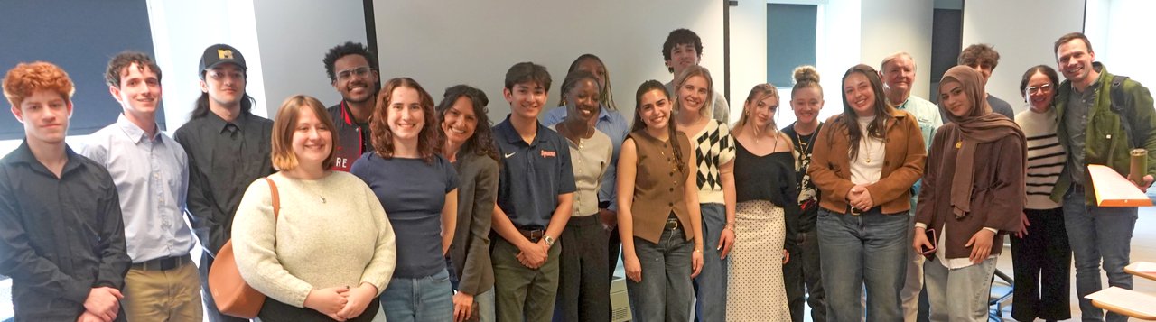 Group of people standing in a room.