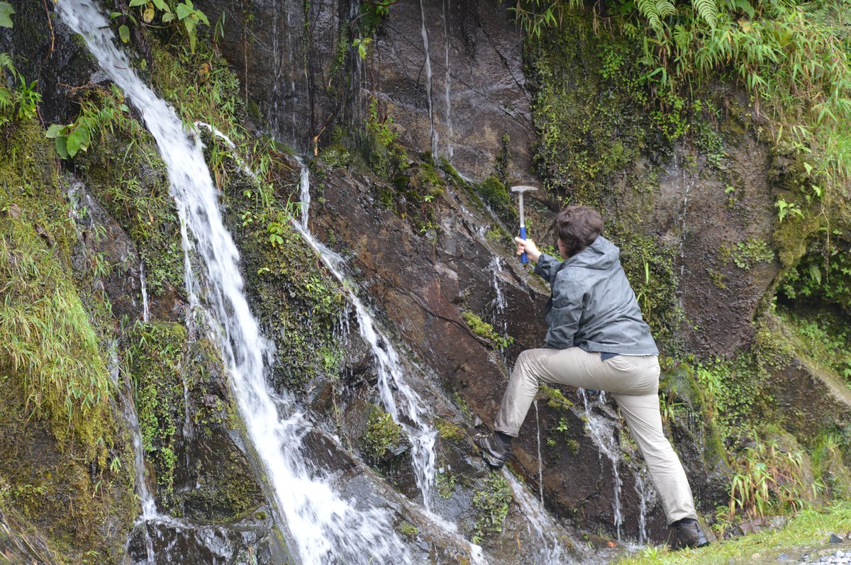 Nicolas Pérez-Consuegra hammering into a rock outcrop to obtain a sample for thermochronology analyses from the mountains in the Putumayo region of Colombia.