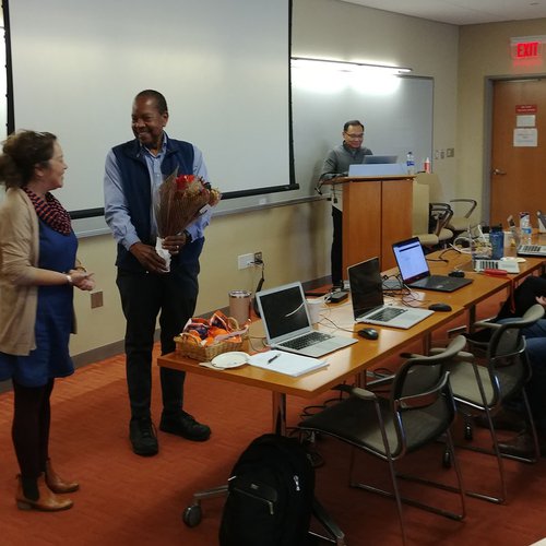 Dean Emeritus George Langford holding flowers at a workshop.