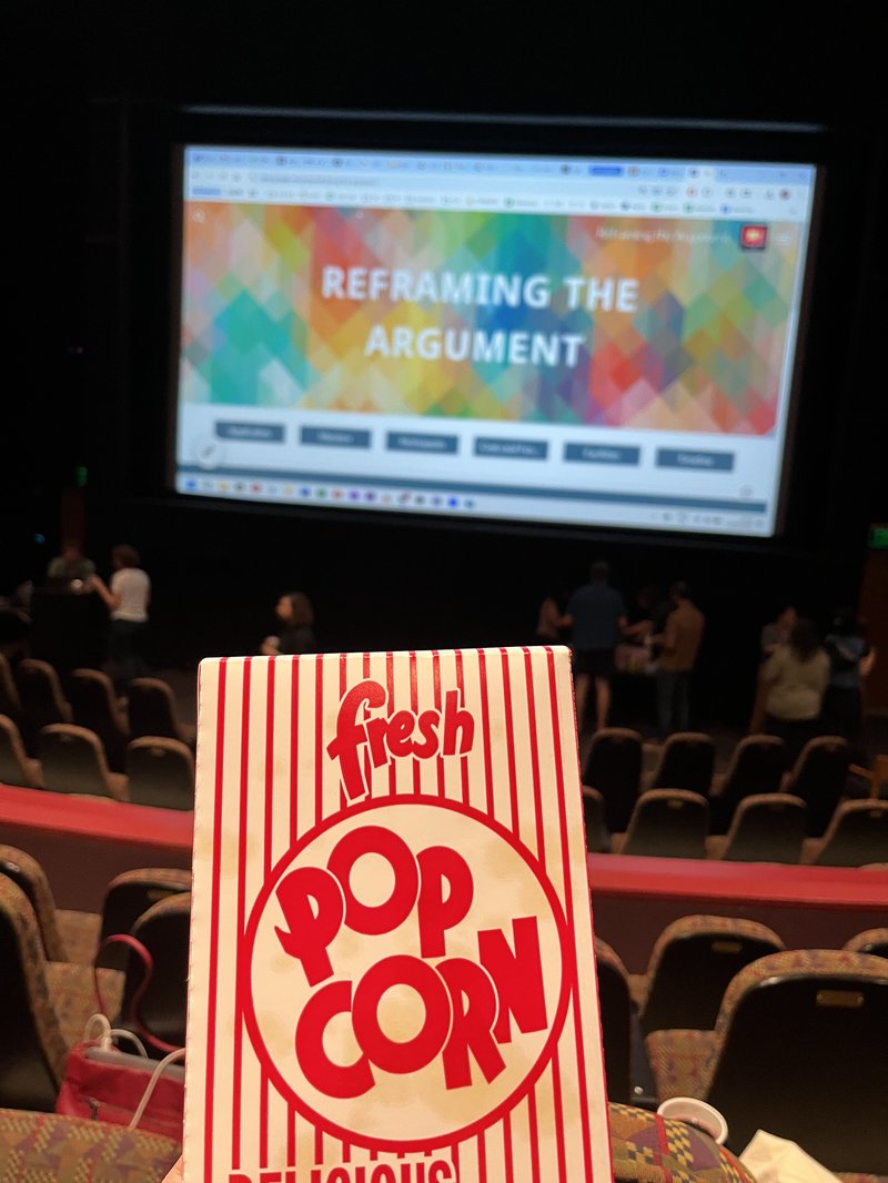 Popcorn box in front of a movie screen.