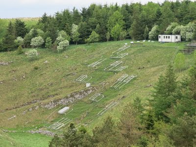 Buxton Climate Change Impacts Laboratory in Derbyshire, England, site of a climate change experiment running for over 15 years. Experimental 3 x 3 meter plots of land exposed to drought and/or heating treatments are marked off across the hillside.