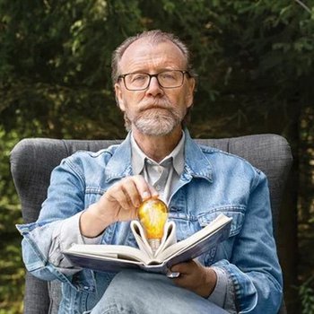 George Saunders holding an open book.