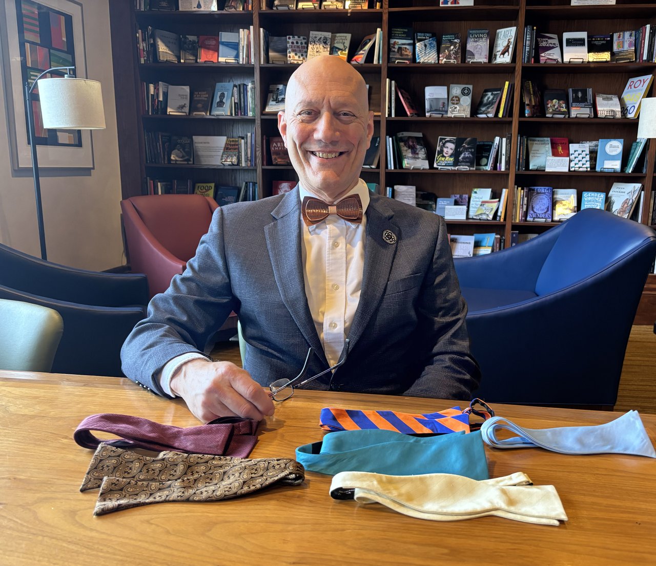 Person sitting at a table with bow ties.