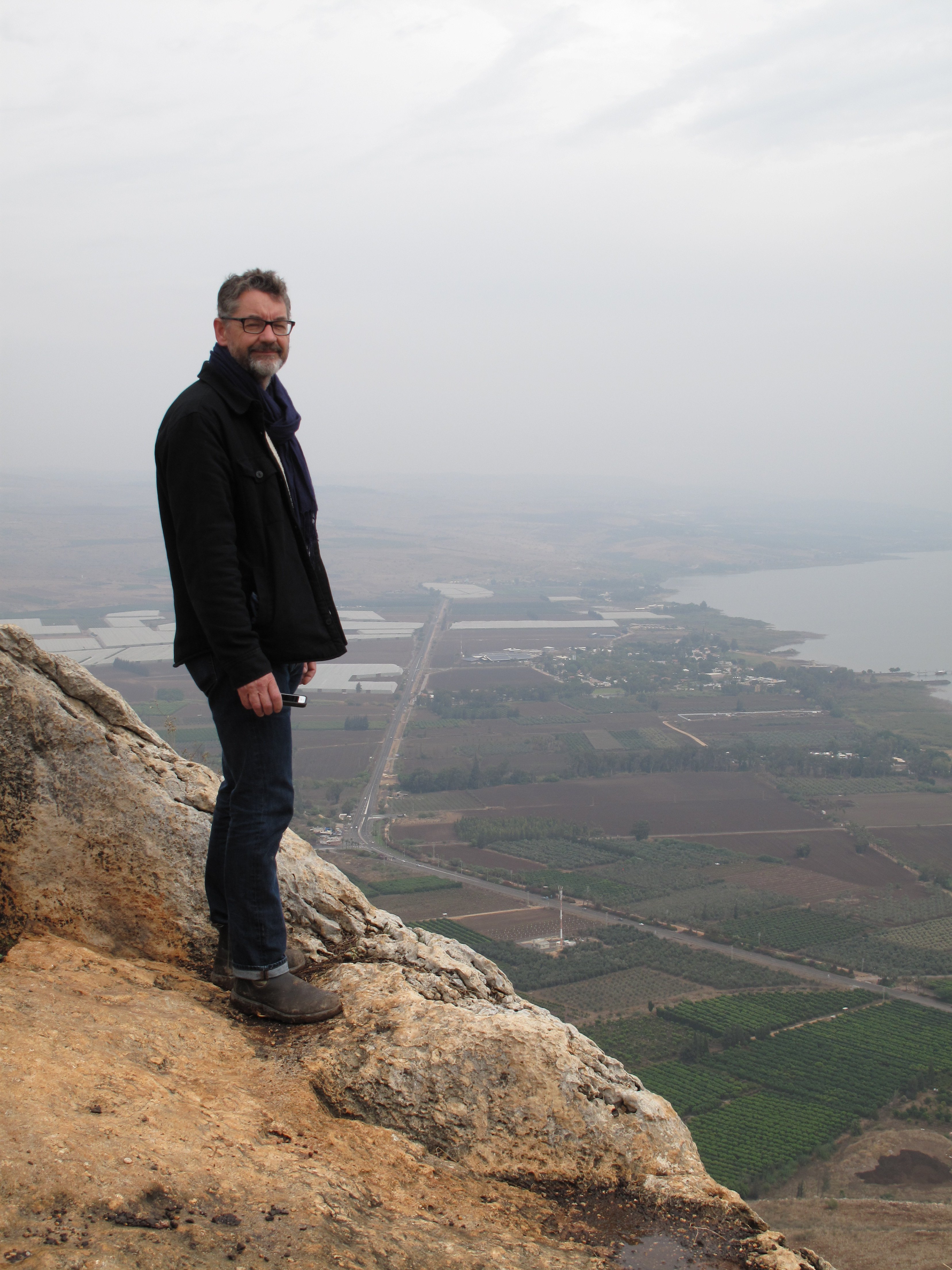 Glenn Peers on top of a mountain with crops in the distance.