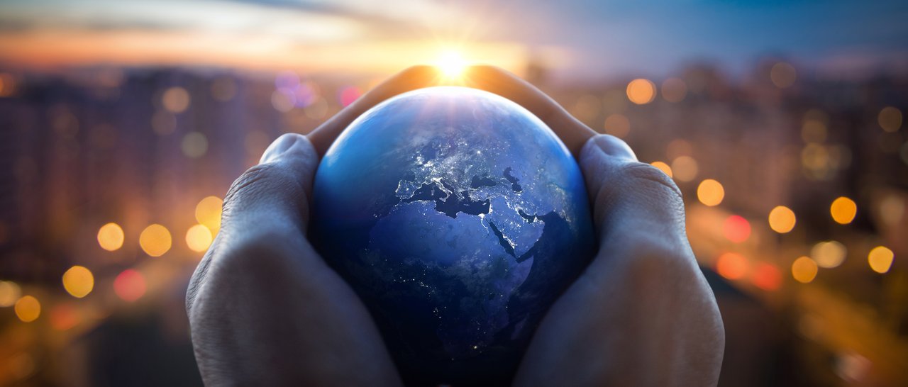 Hands holding a small globe.