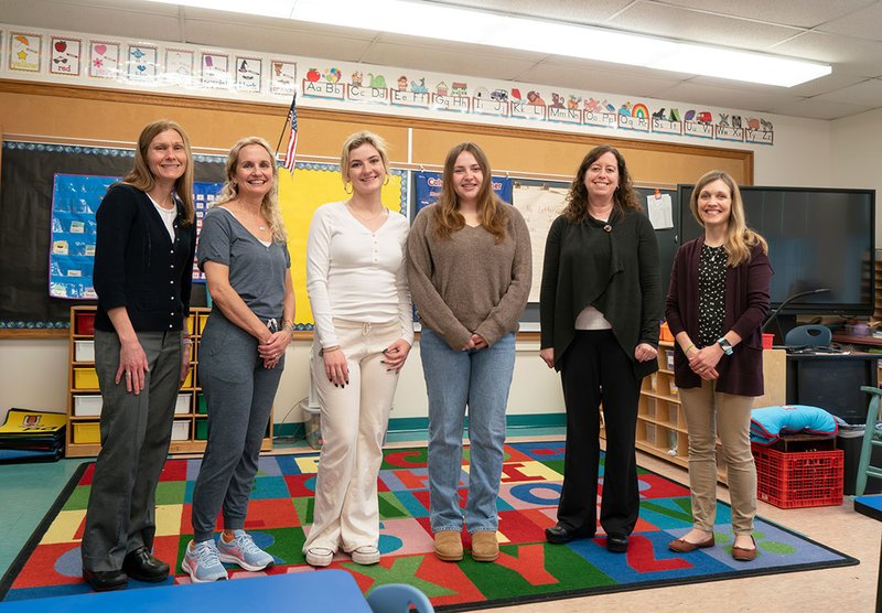 Six women standing in a classroom.