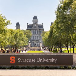 Syracuse University sign with Hall of Languages in the background.