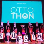 People on a stage holding letters and numbers.