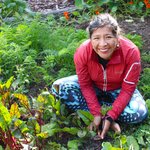 Mariaelena Huambachano sitting in her garden amongst vegetables