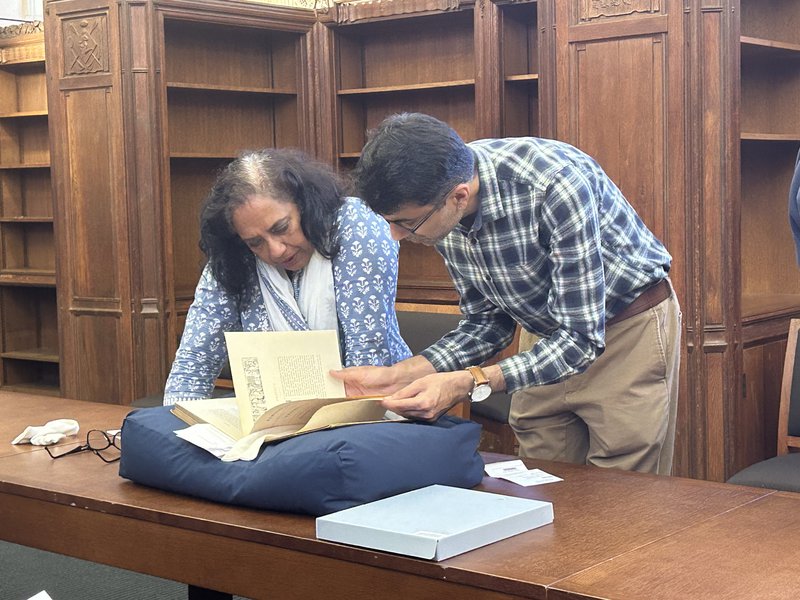 Vinita Damodaran and Ankush Arora studying a rare book
