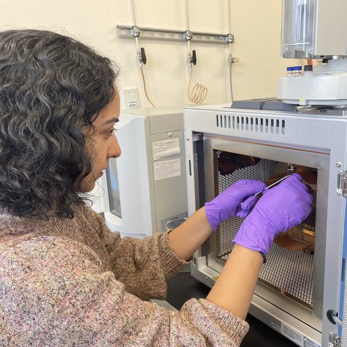 Bhattacharya performs maintenance on her gas chromatograph, a key piece of lab equipment that allows her to quantify the concentrations of leaf waxes in ancient sediments.
